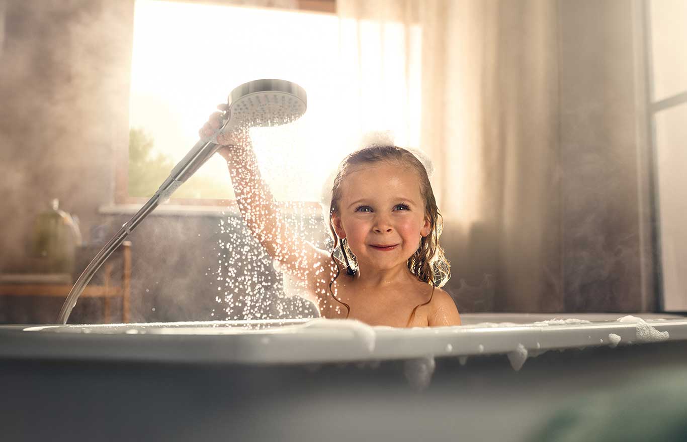 Kind in der Badewanne mit Handbrause